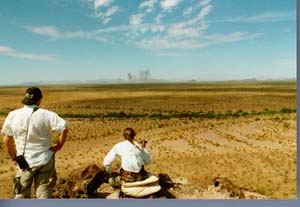 Luke Air Force Base biologist Bill Miller and UA graduate reasearch assistant Debbie Landon observe pronghorns and military activity in the distance. 