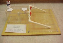 photograph of plexiglass model of a septic tank with two trenches